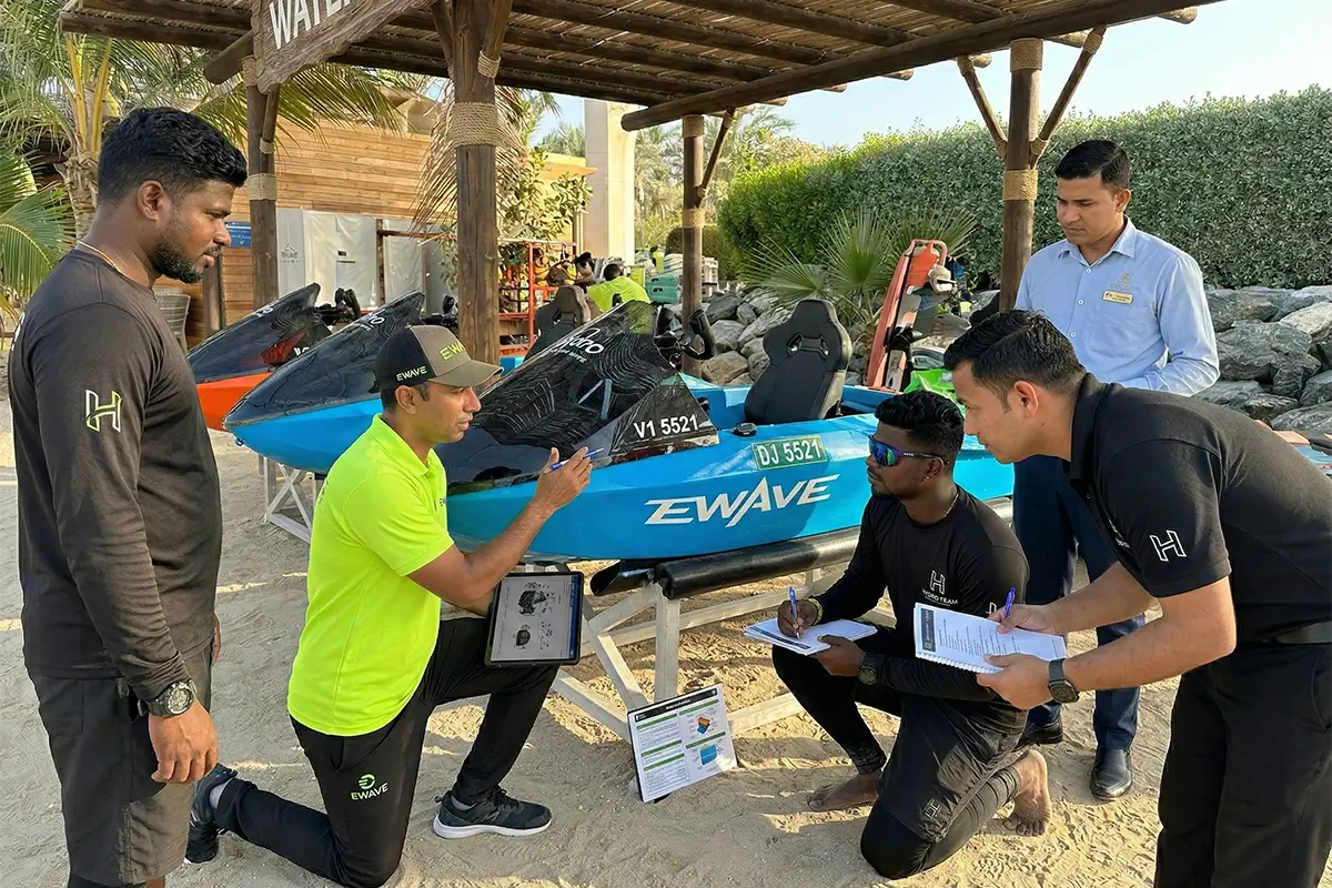 EWAVE staff training a hotel team next to a blue jetboat